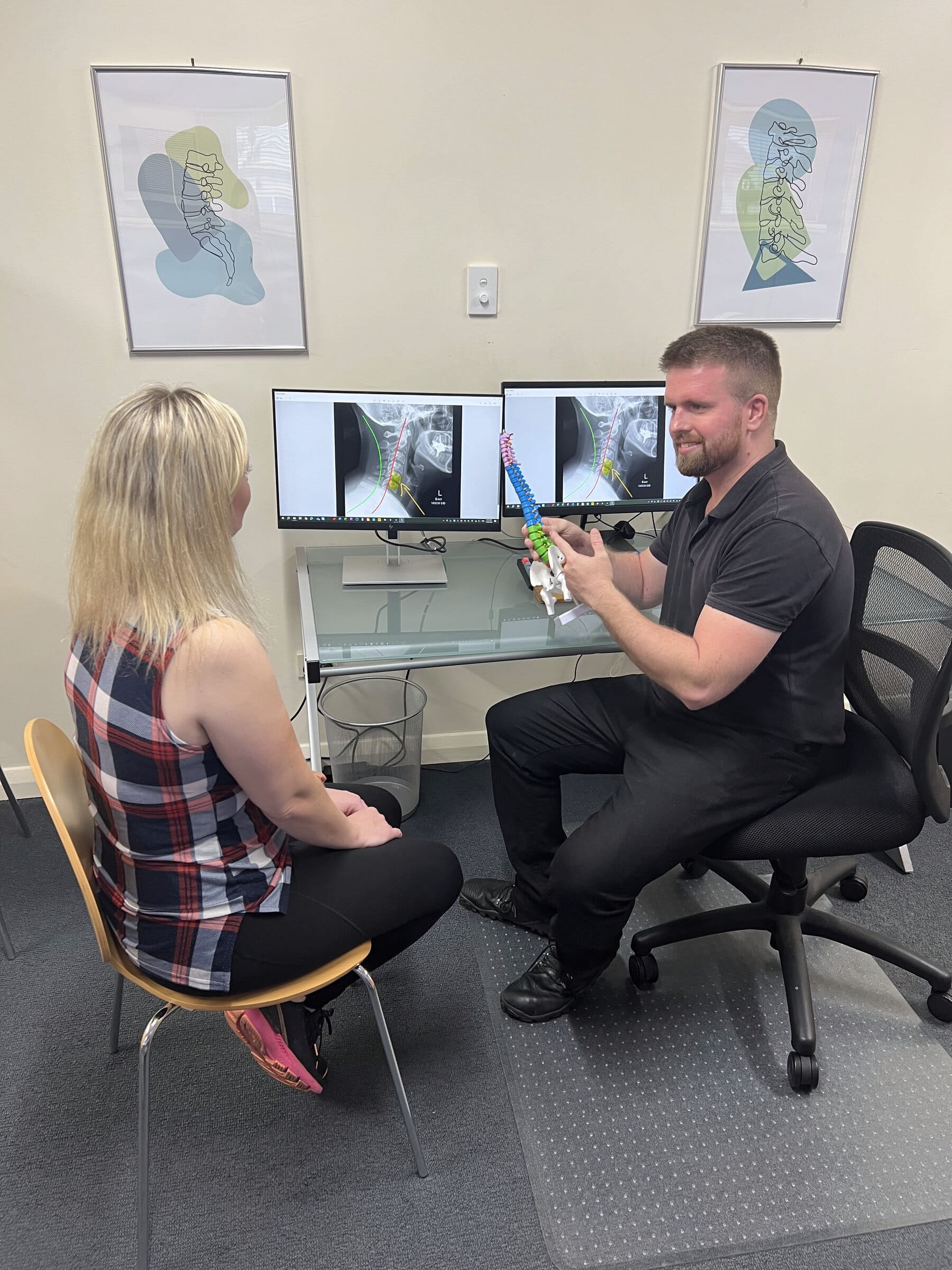 Dr Sam Johnson reviewing findings on tablet during chiropractic consultation