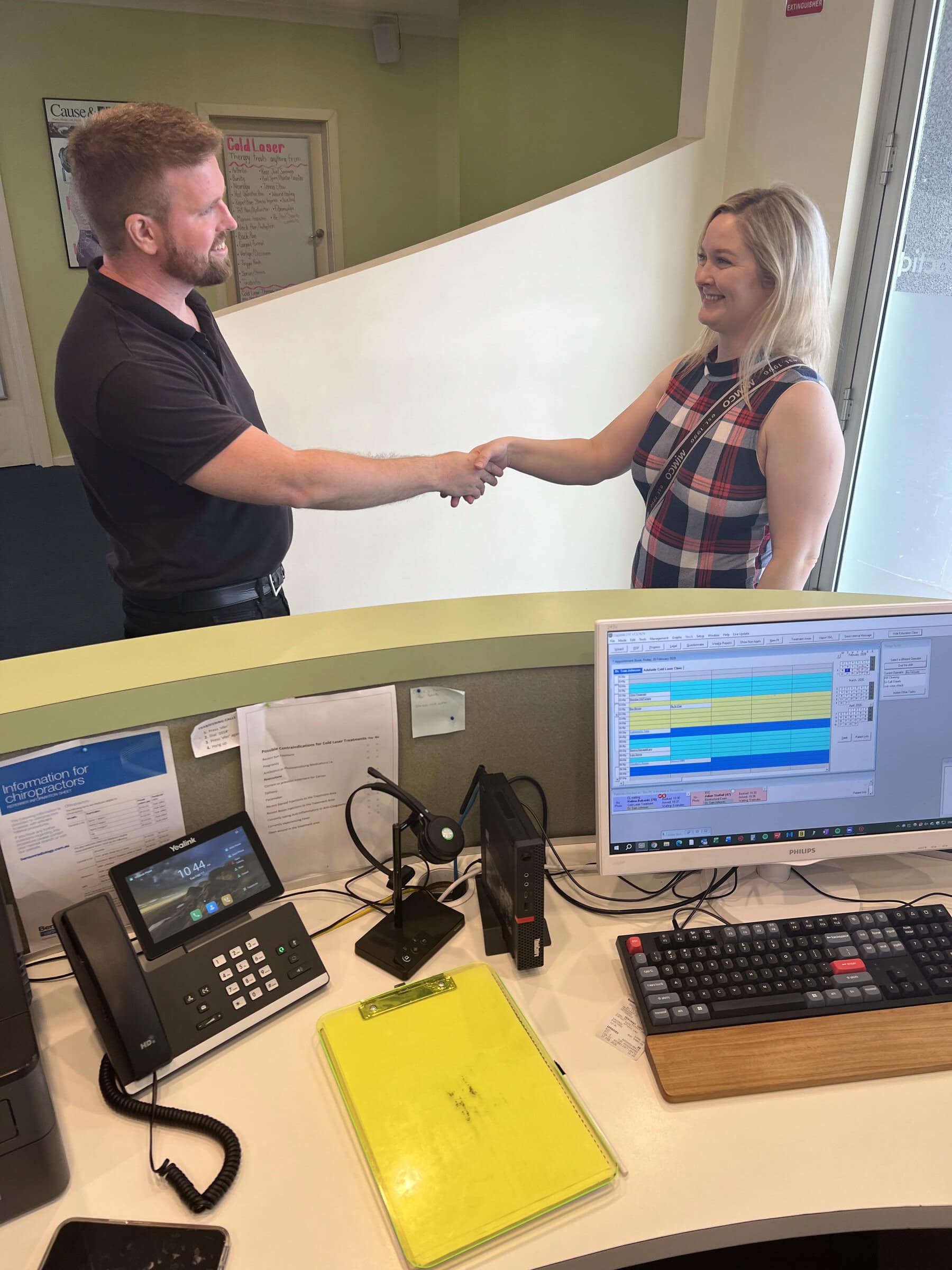 Warm welcome handshake at Stapleton Chiropractic reception desk Plympton Park