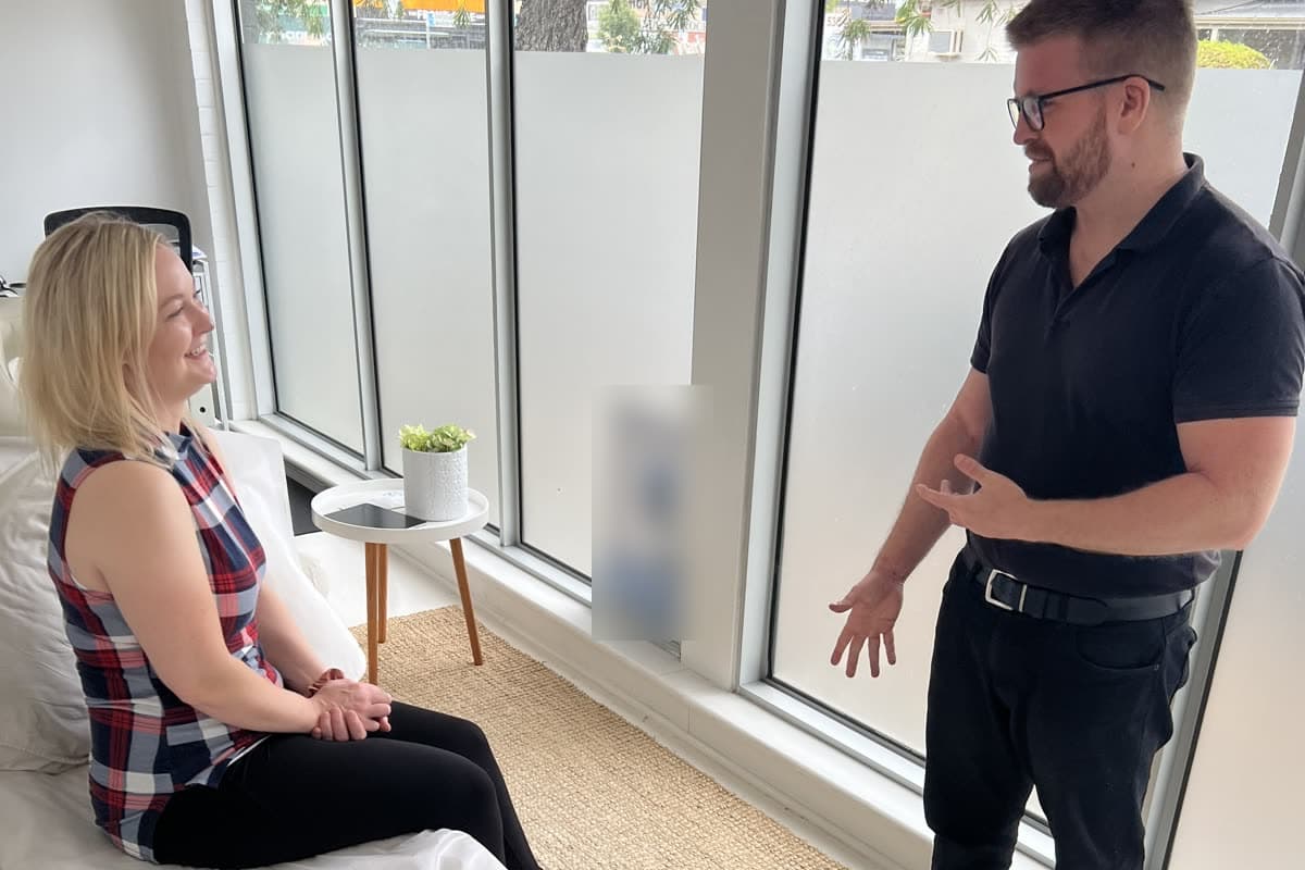 Dr Sam Johnson (Chiropractor) listening to a patient at the start of a first visit
